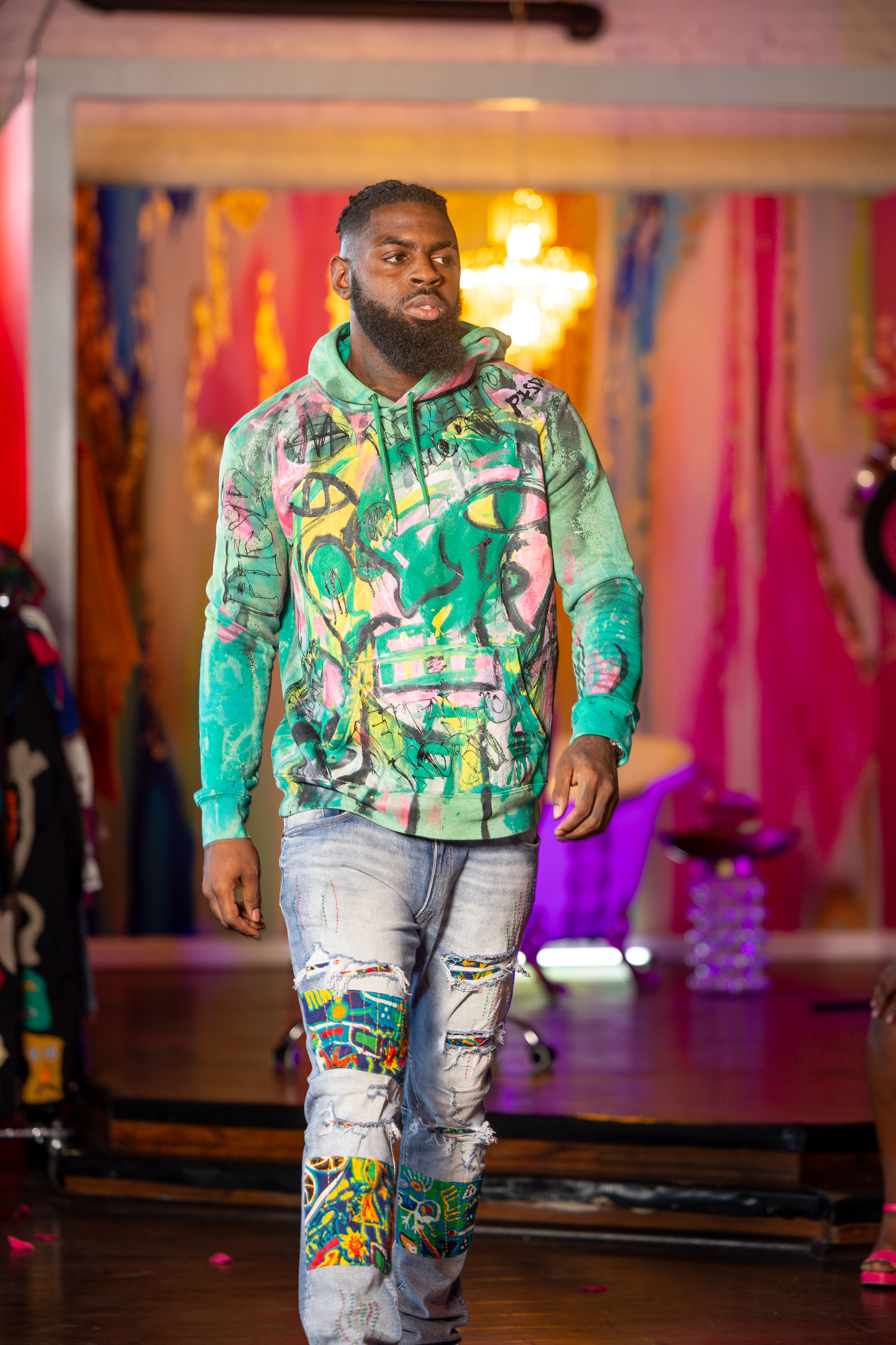Hand-painted hoodie with green graffiti artwork on the runway