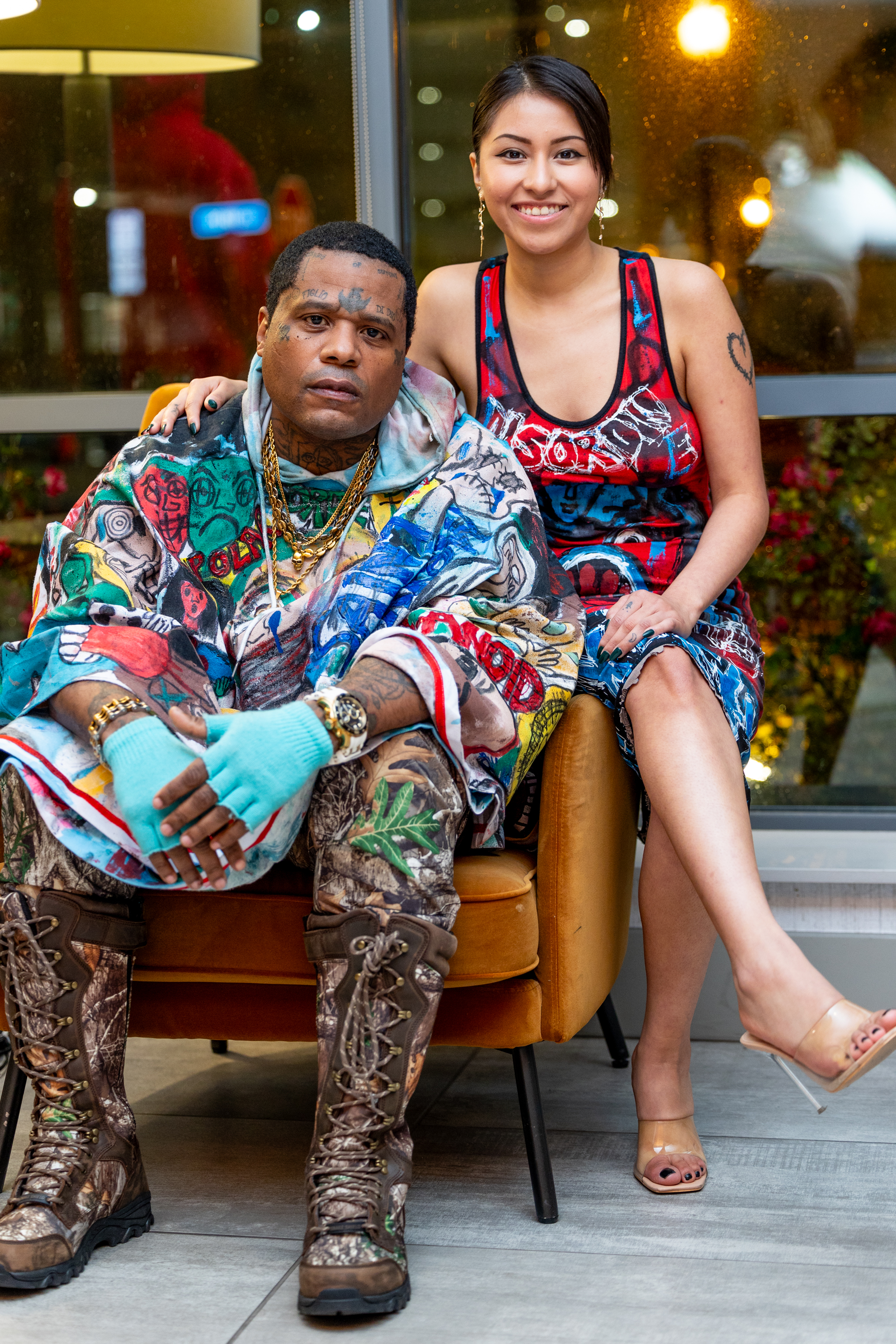 Franco and model seated in hand-painted poncho and red Anxiety dress