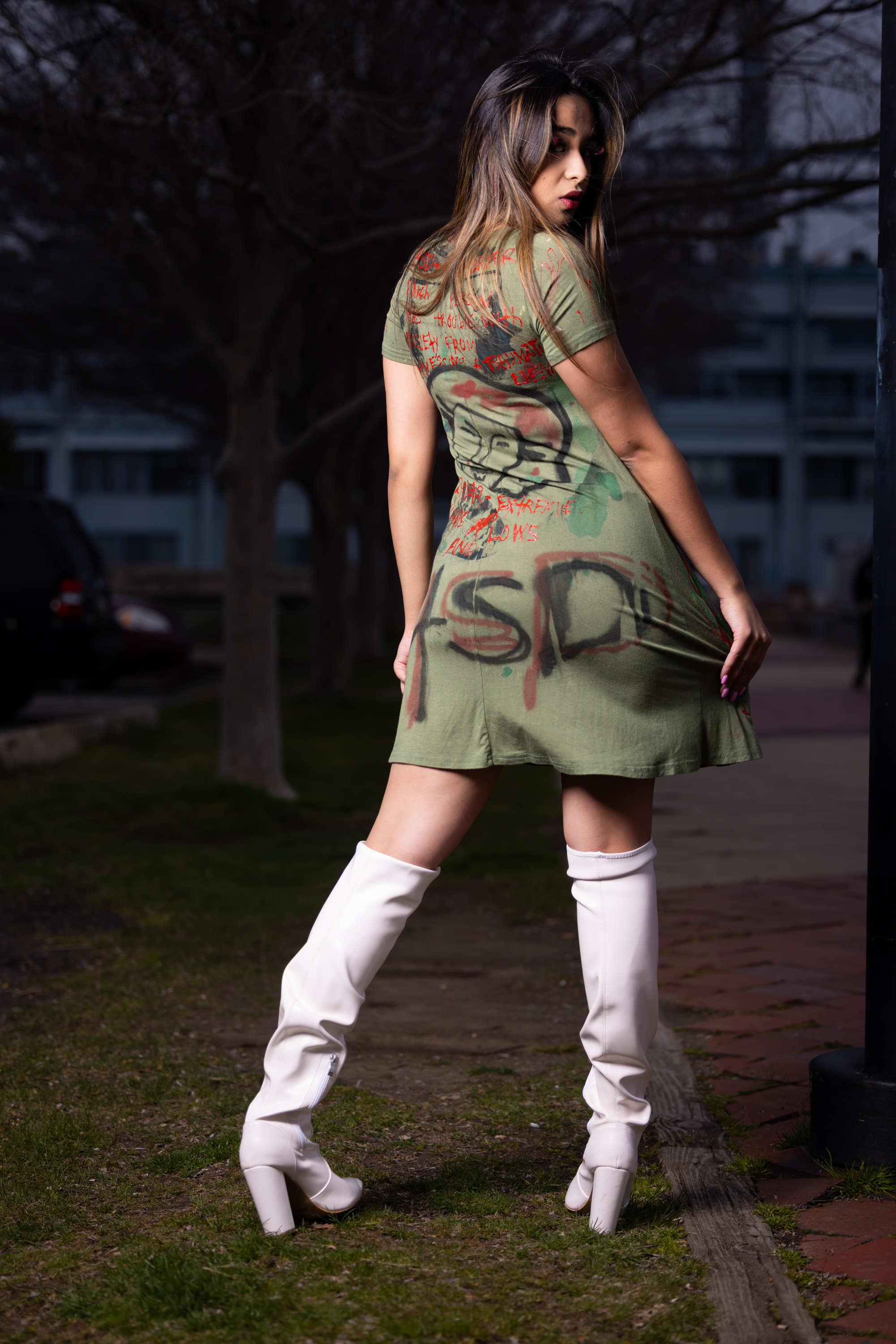 Model wearing hand-painted DiSoRdInE apparel by the waterfront at dusk