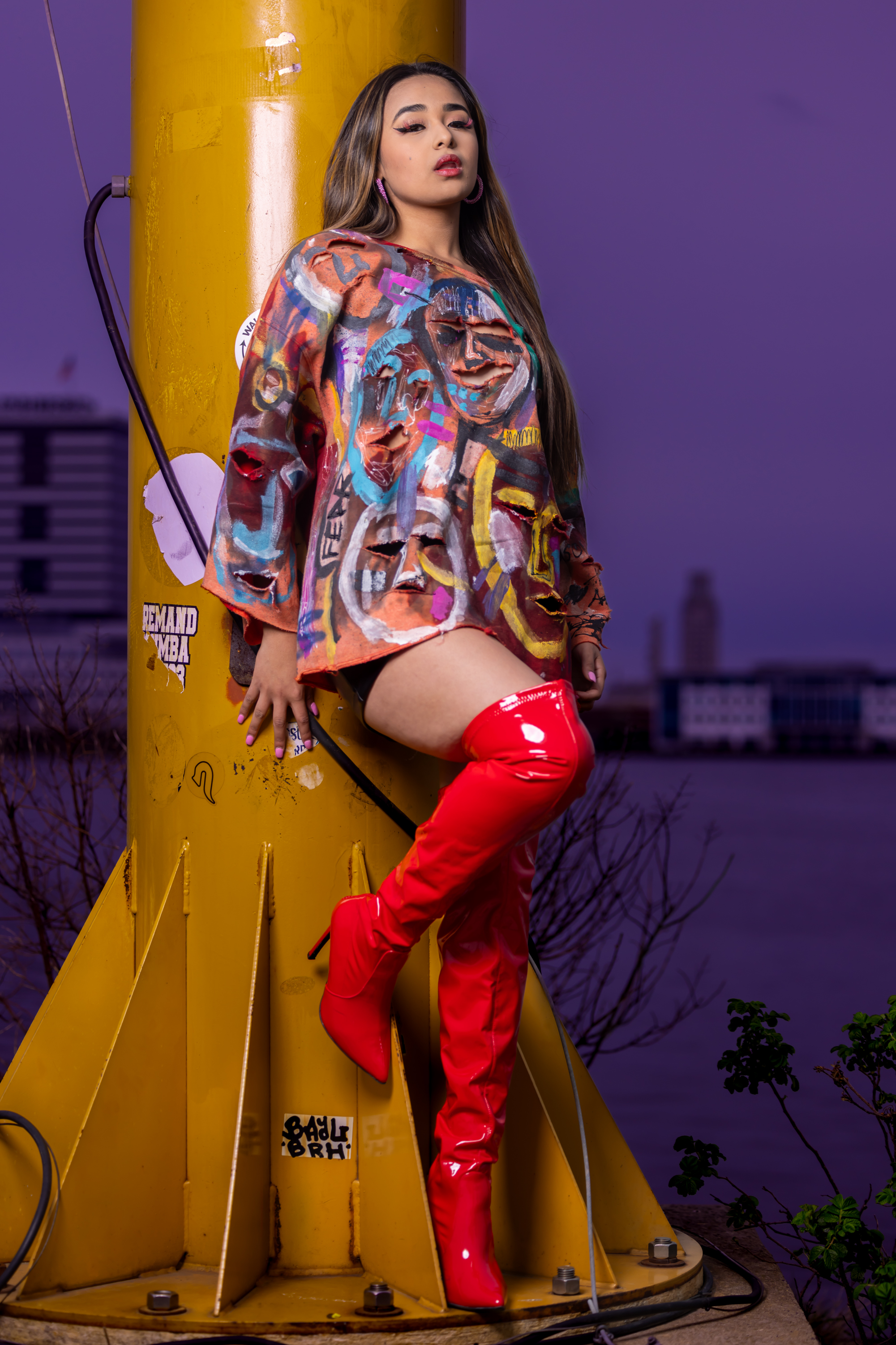 Model posing in a hand-painted DiSoRdInE piece by the Philadelphia riverfront at dusk