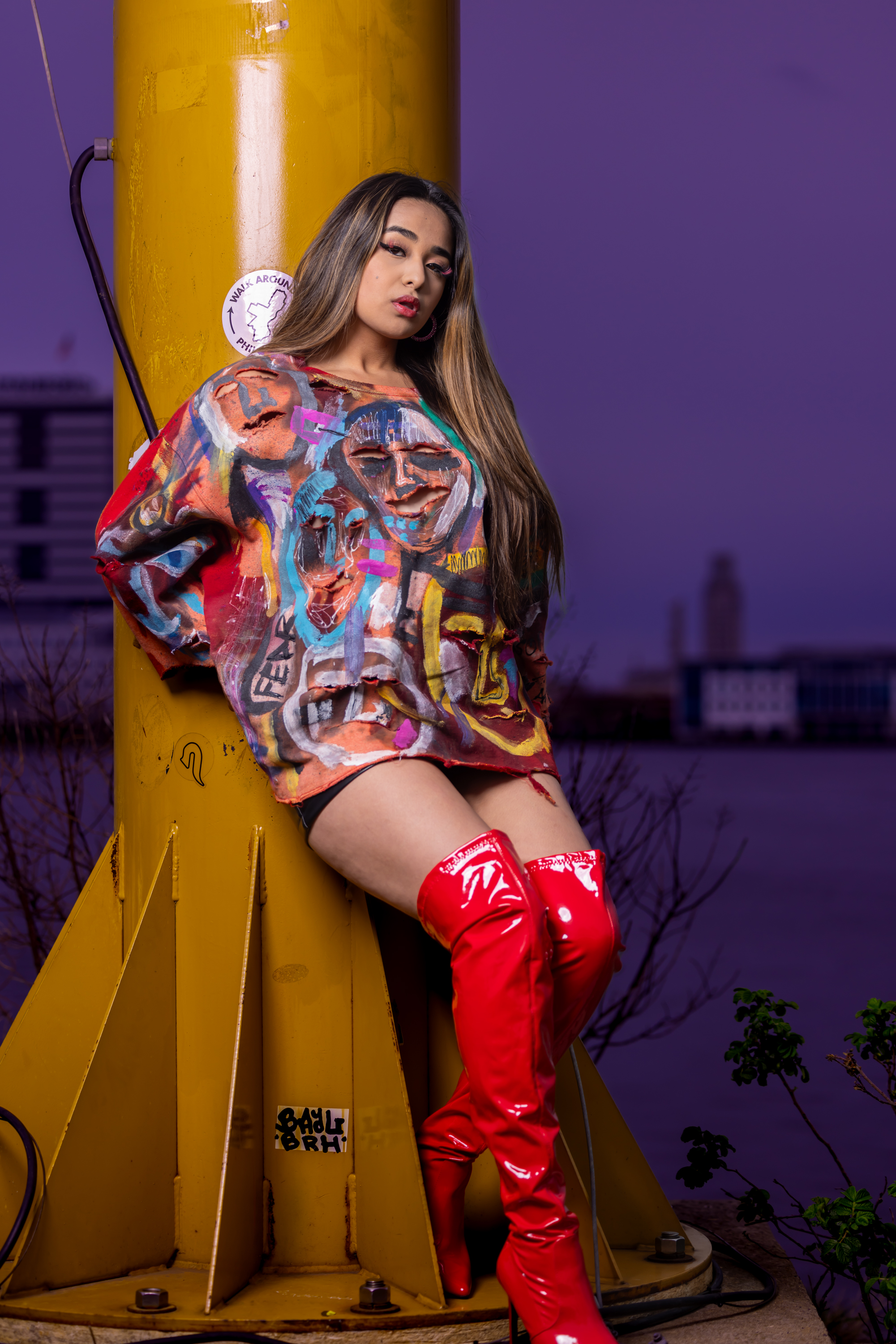 Model in hand-painted DiSoRdInE apparel along the waterfront at twilight
